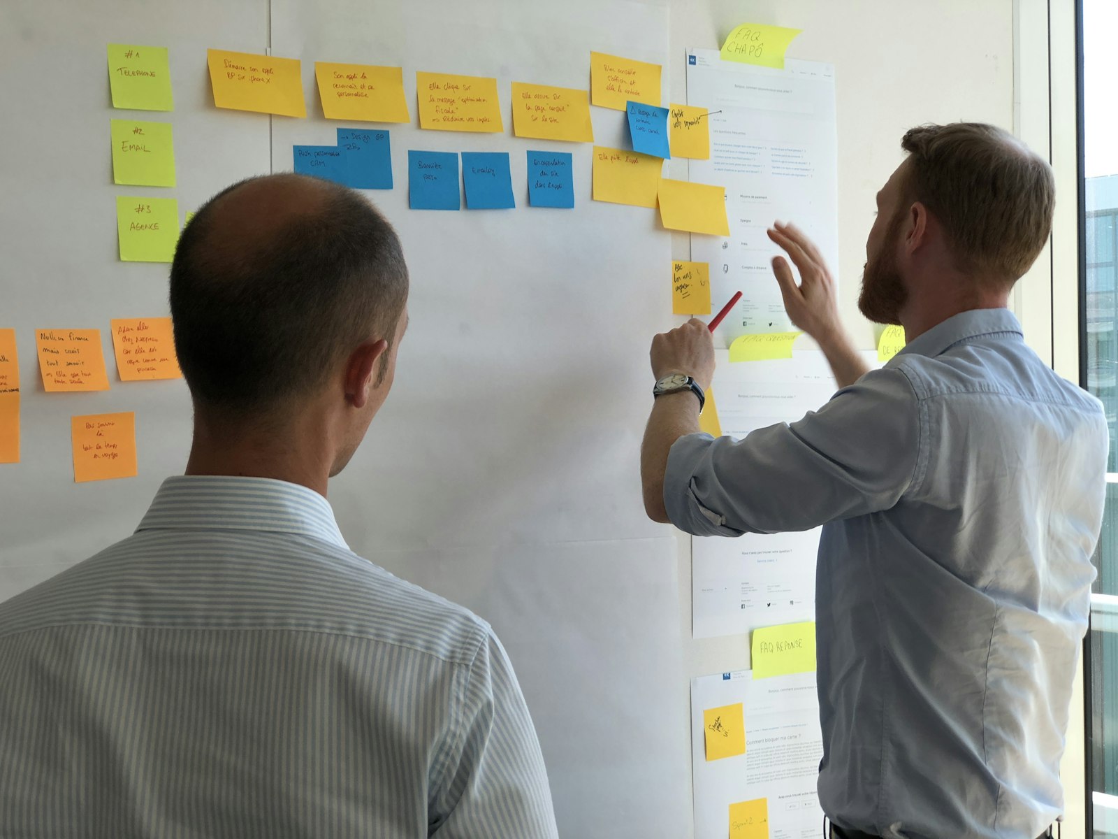 Consultant RH qui anime un atelier avec des post-it face à une équipe de managers