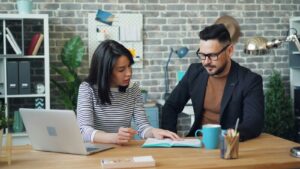 Un homme et une femme travaillent ensemble à une table pour définir un poste